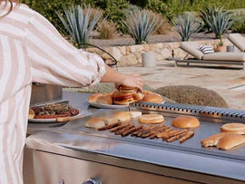 Outdoor BBQ grill in use, cooking burgers and buns on a patio setup