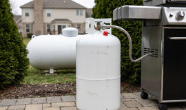 Residential propane tank installed in a backyard garden
